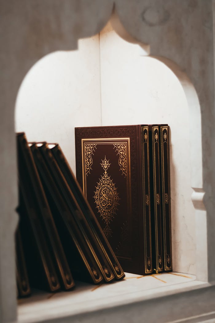 Intricately designed Quran covers elegantly displayed in an ornate niche, symbolizing Islamic culture.
