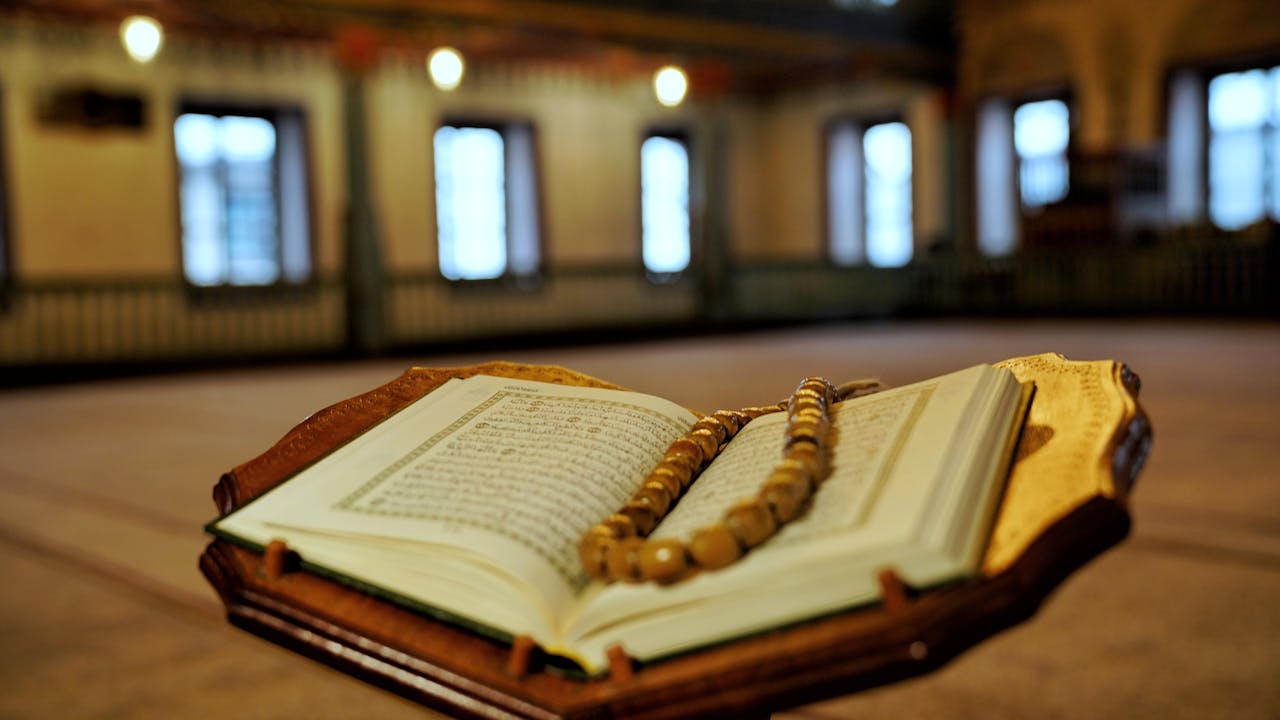 Open Quran with prayer beads in a mosque in Travnik, Bosnia. Peaceful ambiance, Islamic spirituality.