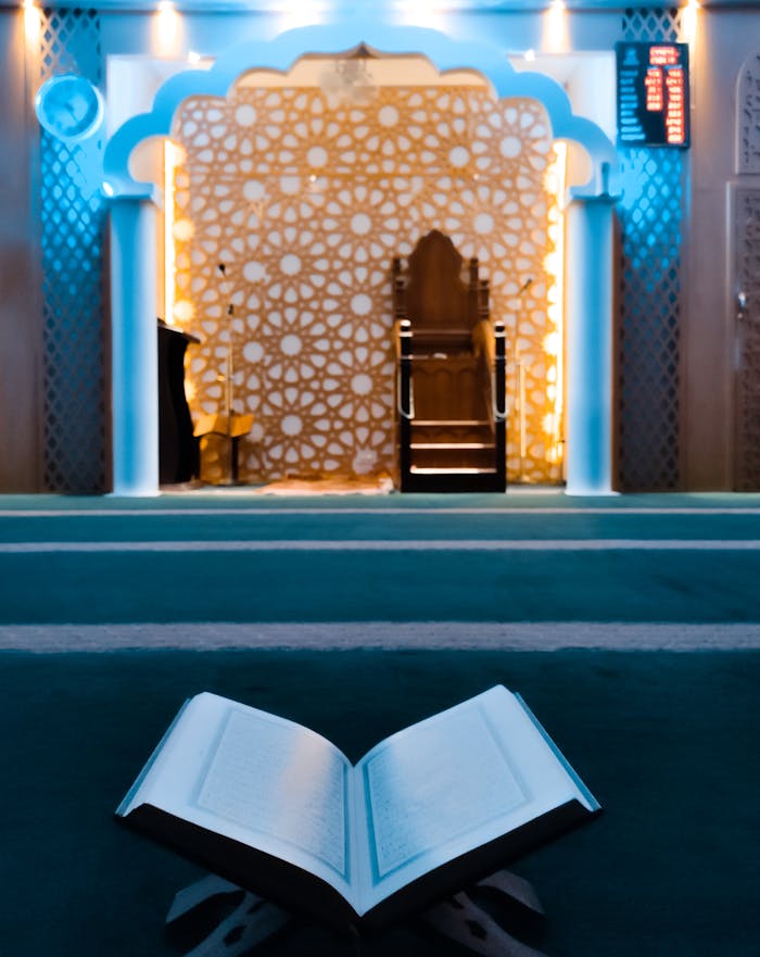 Mastering the First Impression: Your intriguing post title goes here A beautifully lit mosque interior featuring an open Quran on a stand. Ideal for religious themes.